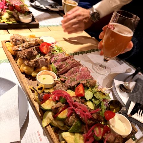 Großes Abendessen – Grillplatte, Gemüse, Bier und Gruppe