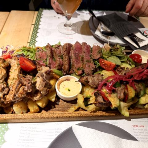 Großes Abendessen – Grillplatte, Gemüse, Bier und Gruppe